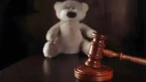 Judge's gavel with teddy bear representing family court proceedings where McKenzie Friend UK 2025 services provide essential court support and self-representation assistance