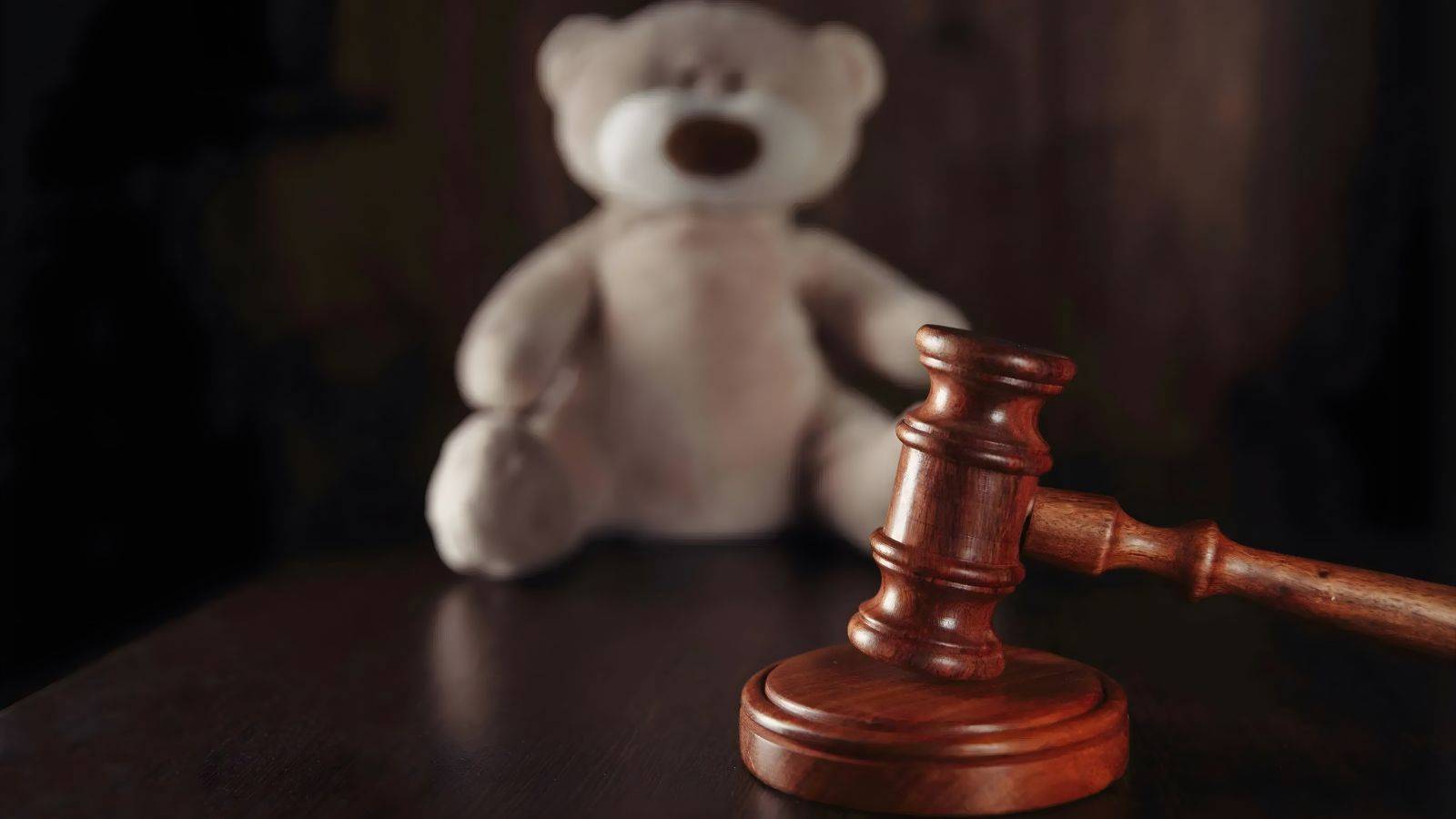 Judge's gavel with teddy bear representing family court proceedings where McKenzie Friend UK 2025 services provide essential court support and self-representation assistance