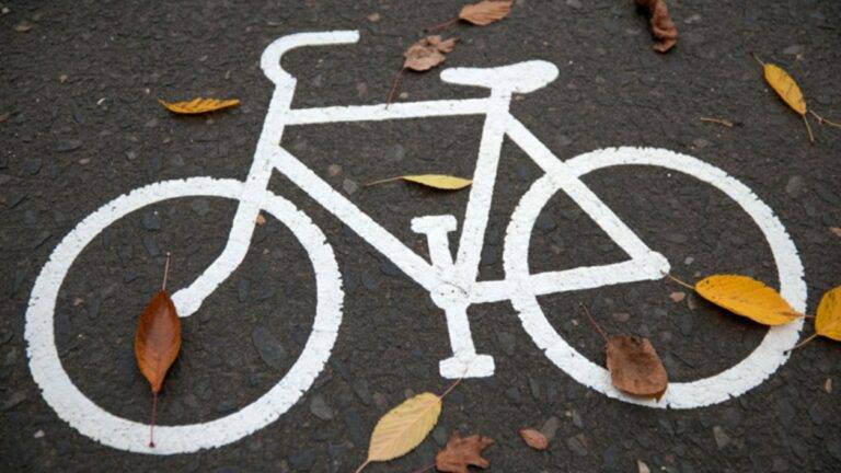 Painted Bicycle Lane Symbol On Uk Road Surface With Autumn Leaves Representing Bicycle Accident Compensation Uk Legal Rights And Cycling Infrastructure Protections